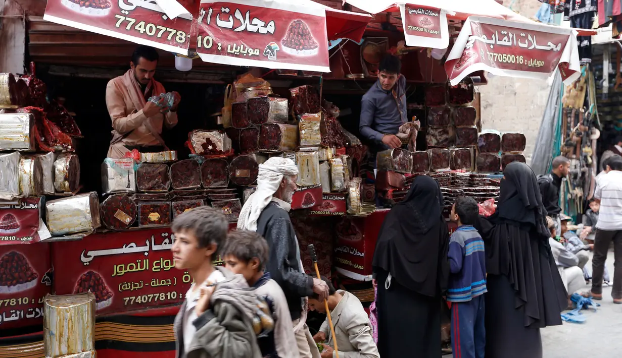 Pedagang kurma melayani pembeli selama bulan suci Ramadan di sebuah pasar di ibukota Sanaa, Yaman (22/5). (AFP Photo/Mohammed Huwais)