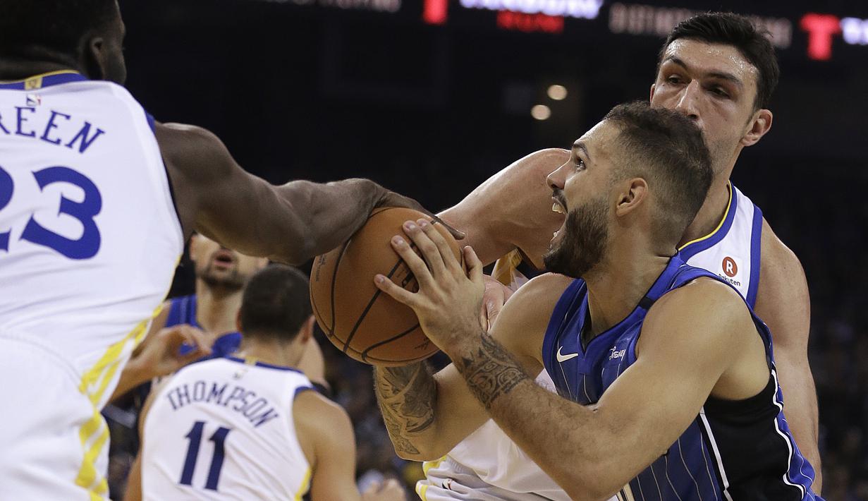 Pemain Orlando Magic, Evan Fournier (tengah) berusaha melewati kepungan pmain Warriors pada lanjutan NBA Basketball game di Oracle Arena, Oakland, (13/11/2017). Warriors menang 110-100. (AP/Ben Margot)
