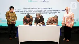 Direktur Utama PT BSI Hery Gunardi (kiri) dan Direktur Eksekutif LPEI Rijani Tirtoso (kanan) menyaksikan penandatanganan nota kesepahaman mengenai penyediaan dan pemanfaatan layanan & produk perbankan syariah di Jakarta, (31/03/2022). (Liputan6.com/HO/BSI)