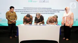 Direktur Utama PT BSI Hery Gunardi (kiri) dan Direktur Eksekutif LPEI Rijani Tirtoso (kanan) menyaksikan penandatanganan nota kesepahaman mengenai penyediaan dan pemanfaatan layanan & produk perbankan syariah di Jakarta, (31/03/2022). (Liputan6.com/HO/BSI)