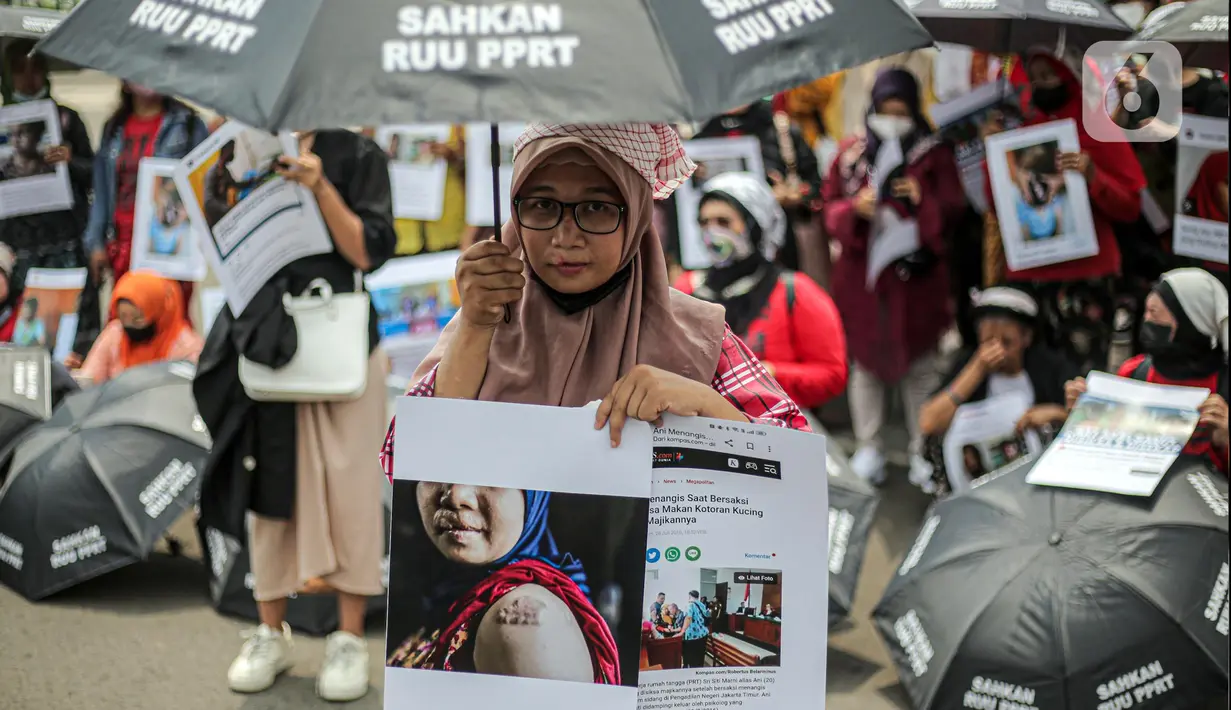 Seorang pekerja rumah tangga (PRT) saat menggelar aksi di depan Taman Aspirasi Monas, Jakarta, Rabu (21/12/2022). Aksi tersebut dilakukan untuk memperingati Hari Ibu serta meminta pemerintah untuk mengesahkan Rancangan Undang-Undang Perlindungan Pekerja Rumah Tangga (RUU PPRT). (Liputan6.com/Faizal Fanani)
