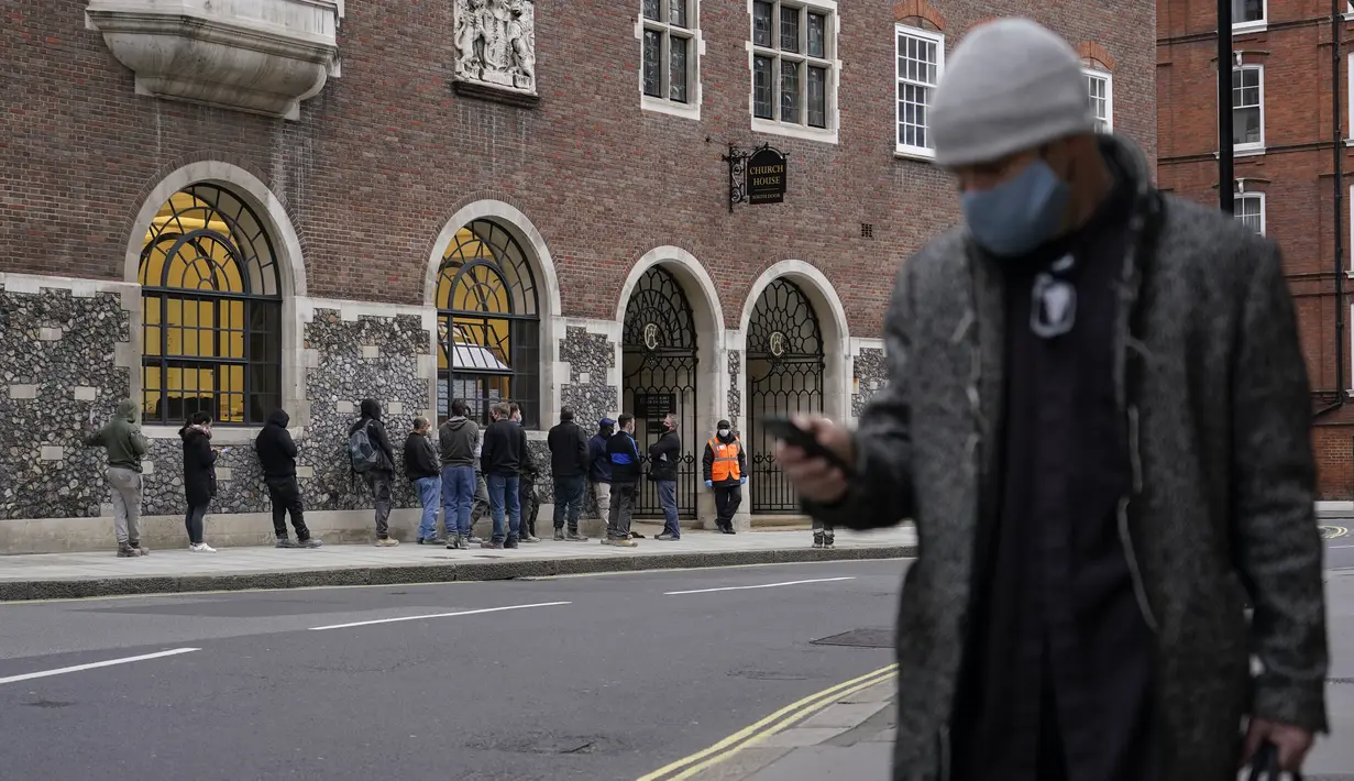 Orang-orang, beberapa memakai masker, mengantre untuk dites, di London, Kamis (16/12/2021). Inggris mencatat 78.610 infeksi baru pada hari Rabu, 16 persen lebih tinggi dari rekor sebelumnya yang ditetapkan pada Januari. (AP Photo/Alberto Pezzali)
