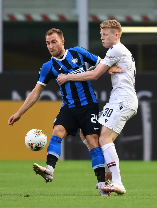 Gelandang Inter Milan, Christian Eriksen (kiri) berebut bola dengan gelandang Bologna, Jerdy Schouten pada pekan ke-30 Serie A 2019-2020, di Stadion Giuseppe Meazza, Minggu (5/7/2020). Inter Milan ditumbangkan Bologna 1-2 di kandang sendiri. (MIGUEL MEDINA / AFP)