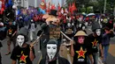 Beberapa buruh berpakaian hitam dan memakai topeng terlihat menggotong boneka babi yang dikalungkan tulisan "Elit Politik & Pengabdi Modal", Kamis (1/5/14). (Liputan6.com/Johan Tallo)