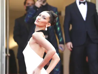 Supermodel Bella Hadid berpose untuk fotografer setibanya di pemutaran perdana film 'Annette' dan upacara pembukaan Festival Film Cannes ke-74 di Prancis selatan, Selasa (6/7/2021). Model berusia 24 tahun itu tampil memukau dengan gaun hitam putih Jean Paul Gaultier. (Vianney Le Caer/Invision/AP)