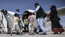 Penumpang berdiri dalam antrean untuk menaiki pesawat Pakistan International Airlines (PIA) di bandara di Kabul, Senin (13/9/2021). Pesawat itu tercatat sebagai penerbangan komersial internasional pertama yang mendarat sejak Taliban merebut kembali kekuasaan di Afghanistan. (Karim SAHIB/AFP)