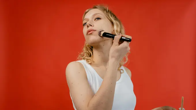 Wanita sedang merias wajah