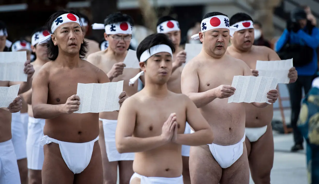 Para penganut Shinto melakukan upacara sebelum menuangkan air dingin ke tubuh mereka dalam ritual ketahanan di Kuil Kanda Myojin, Tokyo, Jepang, Sabtu (26/1). Ritual ini untuk mensucikan jiwa dan raga. (Martin Bureau/AFP)