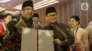 Pasangan Gubernur dan Wakil Gubernur Provinsi Daerah Khusus Jakarta terpilih, Pramono Anung dan Rano Karno menunjukkan surat keputusan Komisi Pemilihan Umum Daerah (KPUD) Jakarta usai menghadiri rapat pleno di Hotel Pullman Central Park, Jakarta, Kamis (9/1/2024). (Liputan6.com/Herman Zakharia)