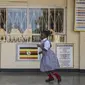 Seorang Siswa berlari di beranda koridor ruang kelas pada hari pertama pembukaan sekolah di Kampala, Uganda pada 10 Januari 2022. Sekolah-sekolah di Uganda dibuka kembali untuk siswa pada Senin (10/1), mengakhiri penutupan sekolah terlama di dunia akibat pandemi COVID-19. (Badru KATUMBA/AFP)