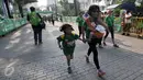 Seorang ibu menggendong anaknya sambil mengikuti lomba Milo Champ Squad Run di area Rasuna Said, Kuningan, Jakarta, Minggu (24/7). (Liputan6.com/Yoppy Renato)