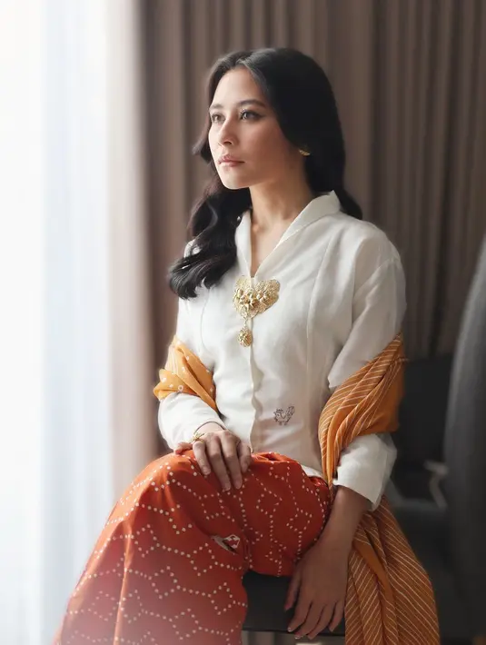 Prilly Latuconsina tampil memesona dibalut kebaya putih dengan padu padan kain bernuansa oranye sebagai rok dan selendang. [Foto: Instagram/prillylatuconsina96]