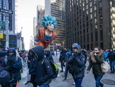 Balon Goku melayang di atas kawasan Sixth Avenue selama Parade Macy's Thanksgiving Day di New York, Kamis (22/11). Balon raksasa berbentuk ikon-ikon kartun terkenal menghiasi gelaran yang digelar untuk ke-92 tersebut. (Don EMMERT / AFP)