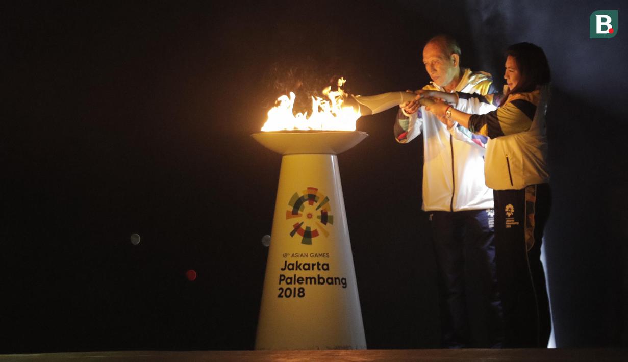 Legenda bulu tangkis Indonesia, Susi Susanti dan mantan atlet tenis Yustedjo Tarik, saat prosesi kirab obor di Candi Prambanan, Rabu (18/7/2018). Api obor Asian Games tersebut akan dibawa mengelilingi 18 provinsi. (Bola.com/M Iqbal Ichsan)
