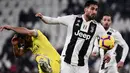 Pemain Chievo, Sergio Pellissier berebut bola dengan gelandang Juventus, Emre Can pada laga pekan ke-20 Serie A di Allianz Stadium, Senin (21/1). Juventus berhasil memantapkan posisi di puncak klasemen setelah menggilas Chievo 3-0. (Marco BERTORELLO/AFP)