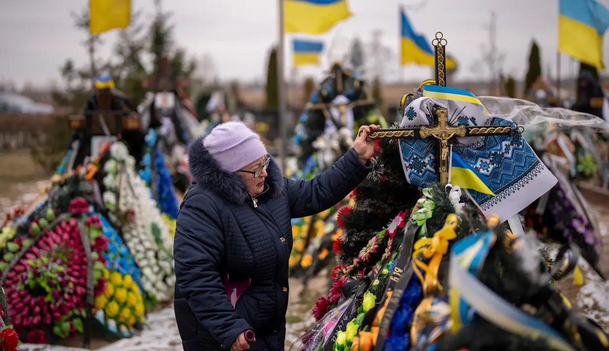 Maria Kurbet, 77 tahun, menangis di makam putranya, seorang prajurit militer yang gugur di Bakhmut, saat upacara peringatan satu tahun dimulainya perang Rusia-Ukraina, di sebuah pemakaman di Bucha, Ukraina, Jumat, 24 Februari 2023. (AP Photo/Emilio Morenatti)