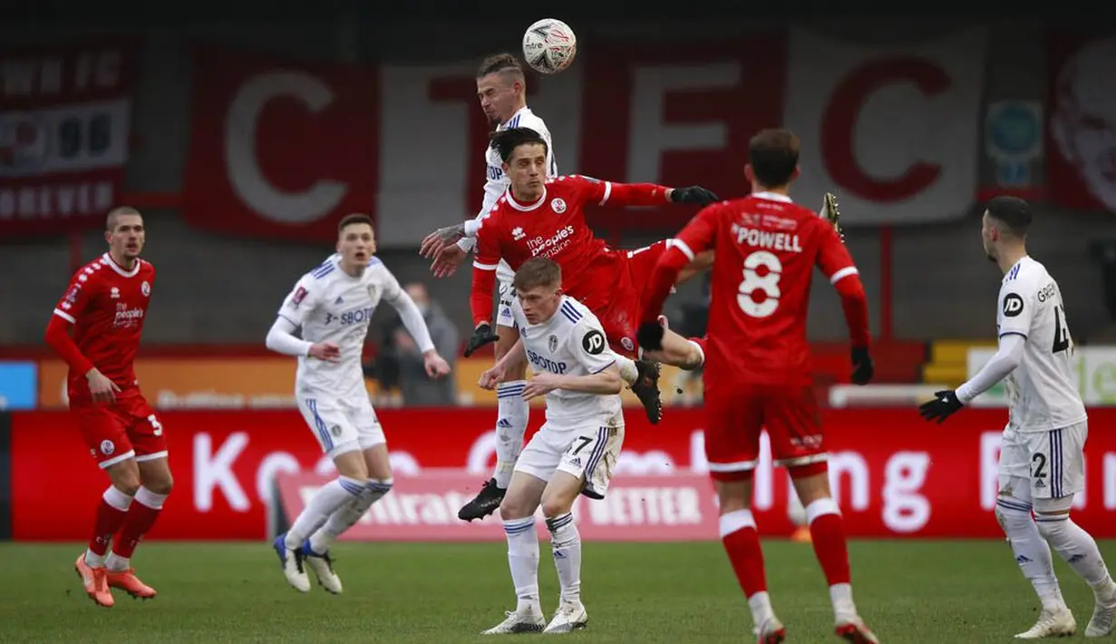 Pemain Leeds United, Kalvin Phillips, duel udara dengan pemain Crawley Town, Tom Nichols, pada laga Piala FA di Stadion Broadfield, Minggu (10/1/2021). Leeds United takluk dengan skor 3-0. (AP Photo/Ian Walton)