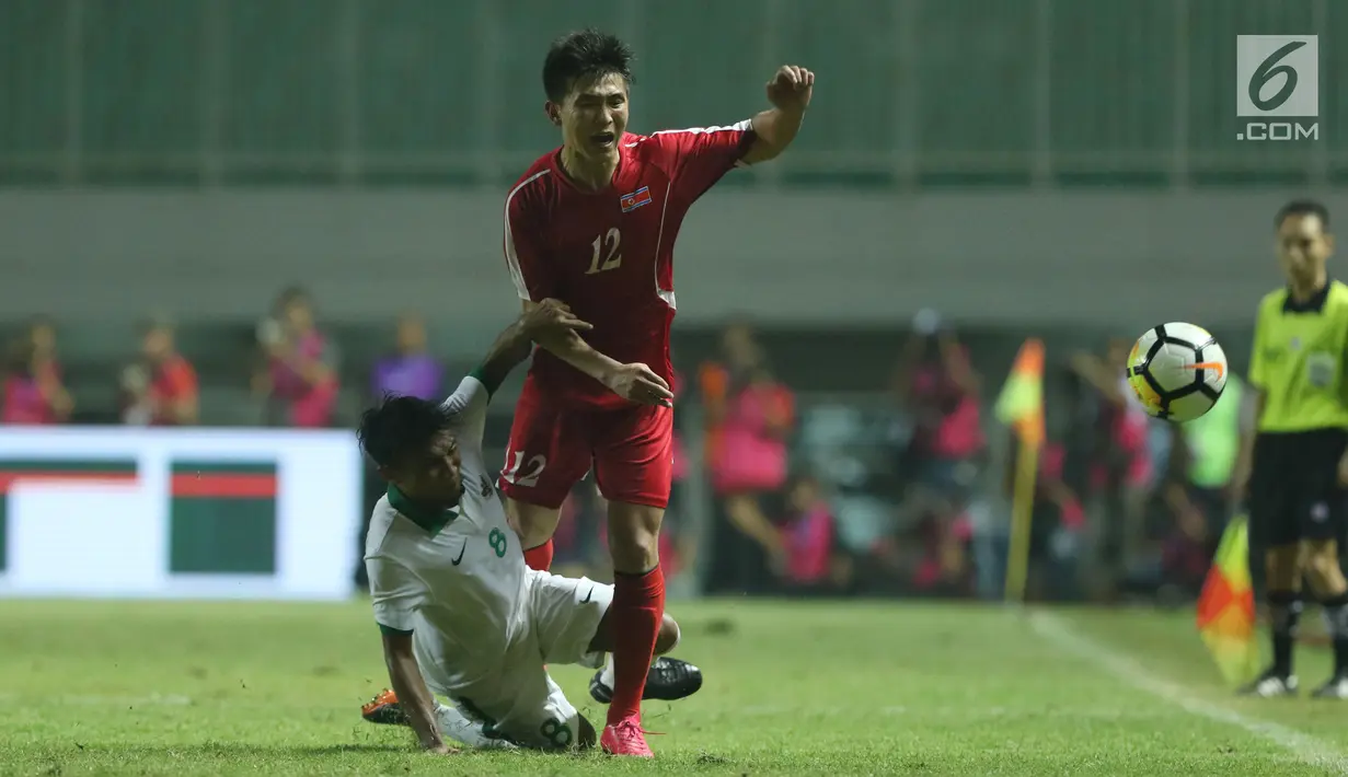 Pemain tengah Indonesia U-23, M Hargianto (bawah) melakukan tekel terhadap pemain Korea Utara, O Chol Hyok pada laga PSSI Anniversary Cup 2018 di Stadion Pakansari, Kab Bogor, Senin (30/4). Laga berakhir imbang 0-0. (Liputan6.com/Helmi Fithriansyah)