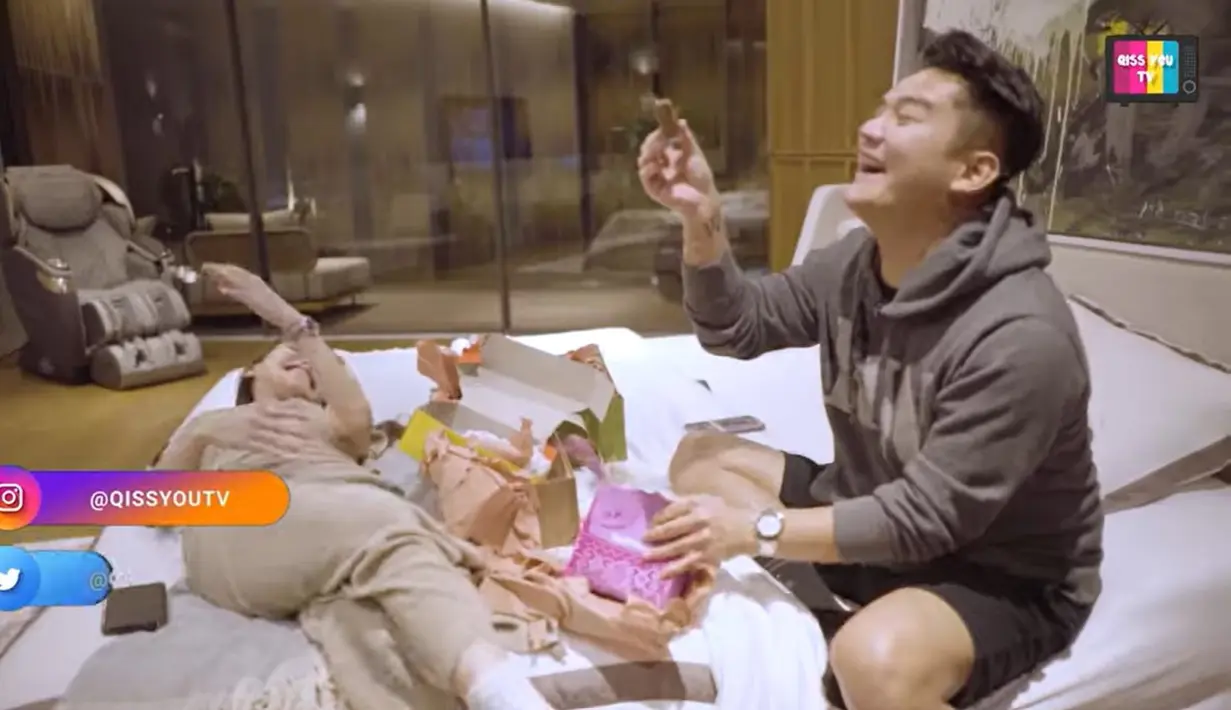 Dan ternyata, bungkusan kotak kecil itu berisi kue. Boy William dan Ayu Ting Ting langsung tertawa terbahak melihat kado tersebut berisi kue khas Betawi. Boy menunjukkan kado yang diluar dugaan. [Youtube/Qiss You TV]