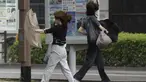 Orang-orang berjalan di tengah hujan badai yang dibawa oleh Badai Tropis Khanun di Kagoshima, Jepang selatan Rabu, 9 Agustus 2023. (Kyodo News via AP)
