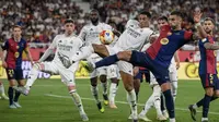 Gelandang Real Madrid asal Inggris #05, Jude Bellingham (tengah), dan penyerang Barcelona asal Spanyol #07, Ferran Torres (kanan), berebut bola selama pertandingan final Piala Spanyol, Copa del Rey (Piala Raja) antara FC Barcelona dan Real Madrid CF di stadion La Cartuja di Seville, Minggu dini hari WIB (30-4-2025). (Josep LAGO/AFP)