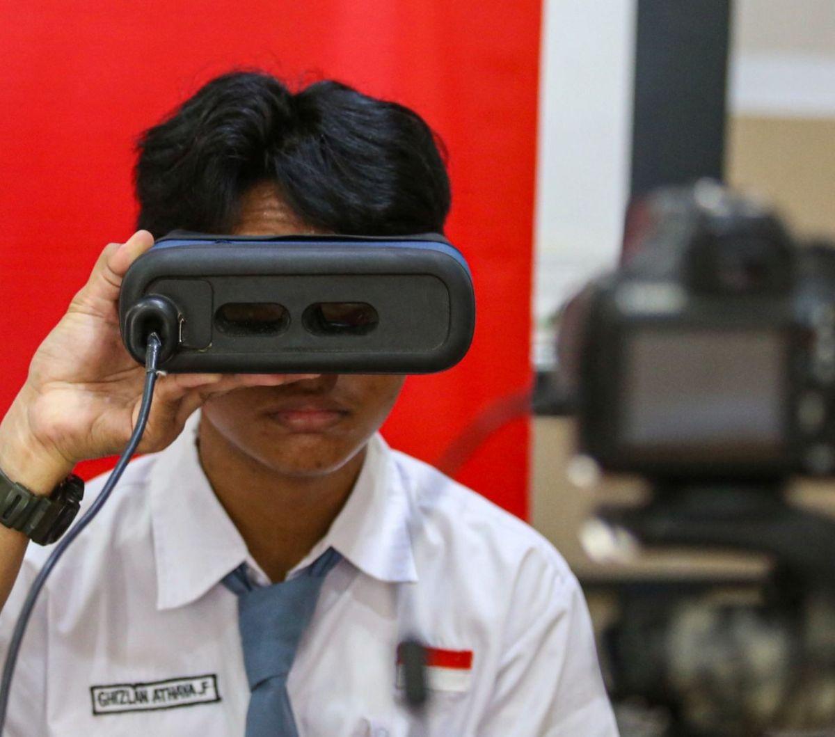 Siswa mengikuti perekaman data identitas retina mata saat perekaman KTP elektronik di SMAN 37 Jakarta, Tebet, Jakarta Selatan, Senin (6/5/2024). (Liputan6.com/Angga Yuniar)