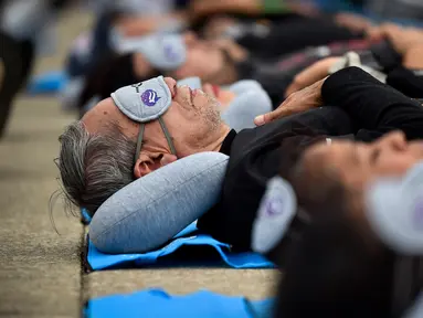 Orang-orang menikmati tidur siang saat menghadiri acara Hari Tidur Sedunia (World Sleep Day) di Monumento a la Revolution, Mexico City, Meksiko, pada 15 Maret 2024. (Rodrigo Oropeza/AFP)