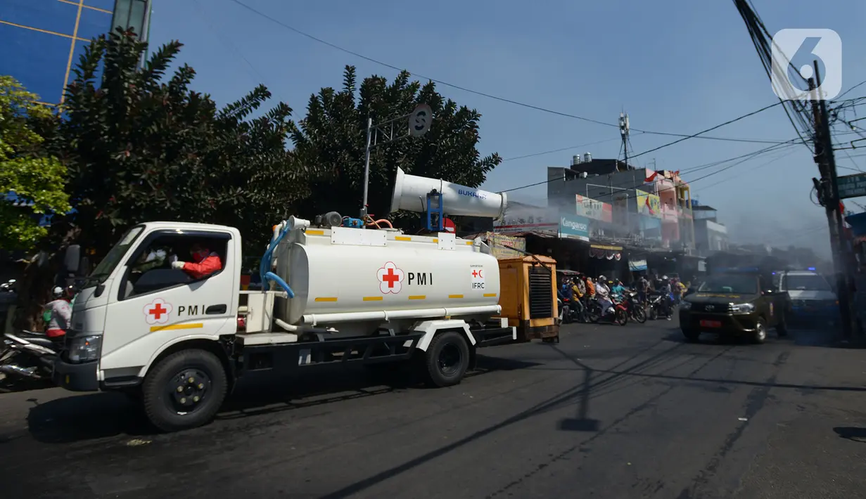 Petugas gabungan melakukan penyemprotan cairan disinfektan di sepanjang jalan raya di wilayah Jakarta Timur, Selasa (25/8/2020). Hal ini mengingat jumlah kasus positif Covid-19 yang meningkat di wilayah Jakarta Timur agar masyarakat tetap sehat dan saling menjaga protokol kesehatan. (merdeka.com/Ima