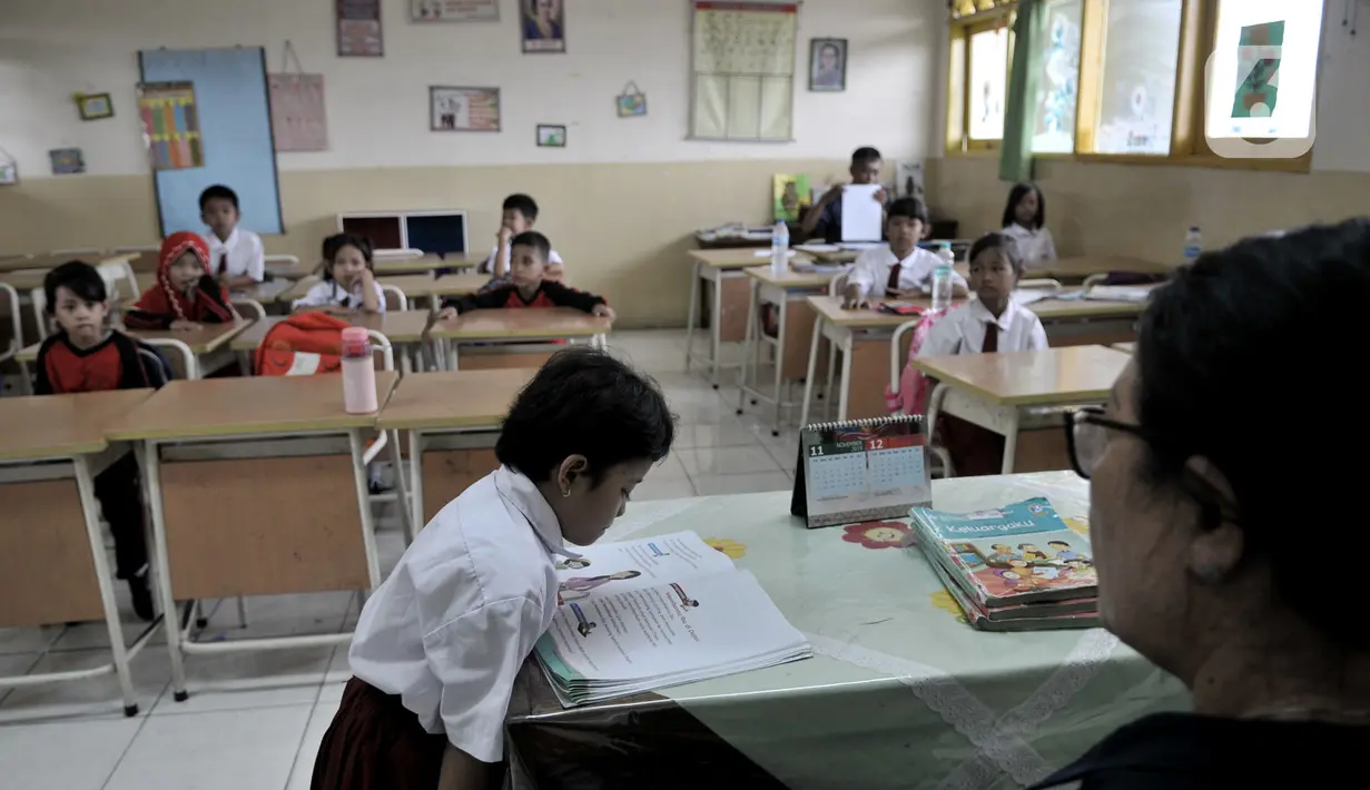 Siswa saat mengikuti kegiatan belajar di salah satu kelas SDN Bukit Duri 11, Jakarta, Senin (6/1/2020). Sebagian siswa di sekolah ini mengenakan pakaian bebas dan sandal akibat seragam serta sepatu mereka hilang terbawa arus banjir. (merdeka.com/Iqbal S. Nugroho)