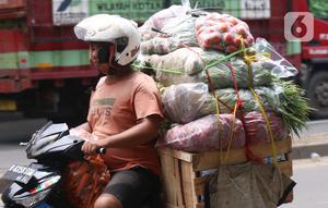Warga membawa bahan makanan dengan sepeda motor saat melintas di kawasan Tangerang, Banten, Rabu (16/2/2022).Bank Indonesia (BI) memperkirakan terjadi penurunan harga komoditas atau deflasi pada Februari 2022. (Liputan6.com/Angga Yuniar)