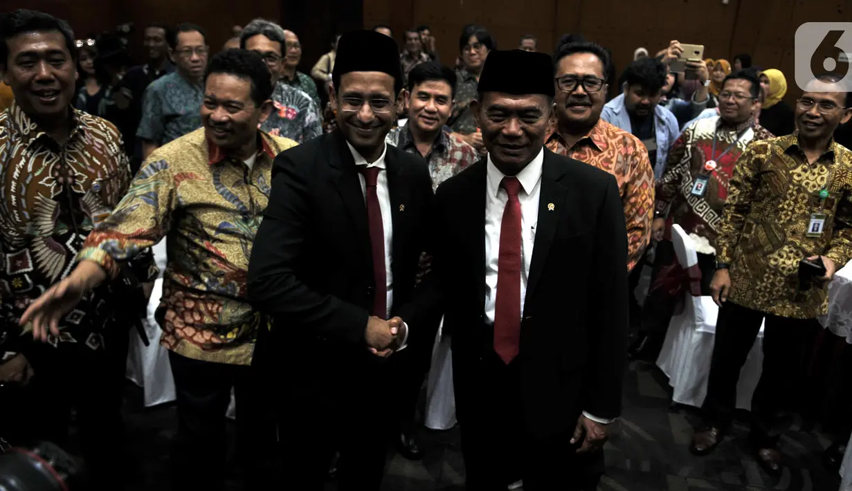 Muhadjir Effendy (kanan) berjabat tangan dengan Nadiem Makarim dalam acara lepas sambut Menteri Pendidikan dan Kebudayaan (Mendikbud) di Gedung Kemendikbud, Jakarta, Rabu (23/10/2019). Nadiem Makarim menggantikan Muhadjir Effendi yang sebelumnya menjabat sebagai Mendikbud (merdeka.com/Iqbal Nugroho)