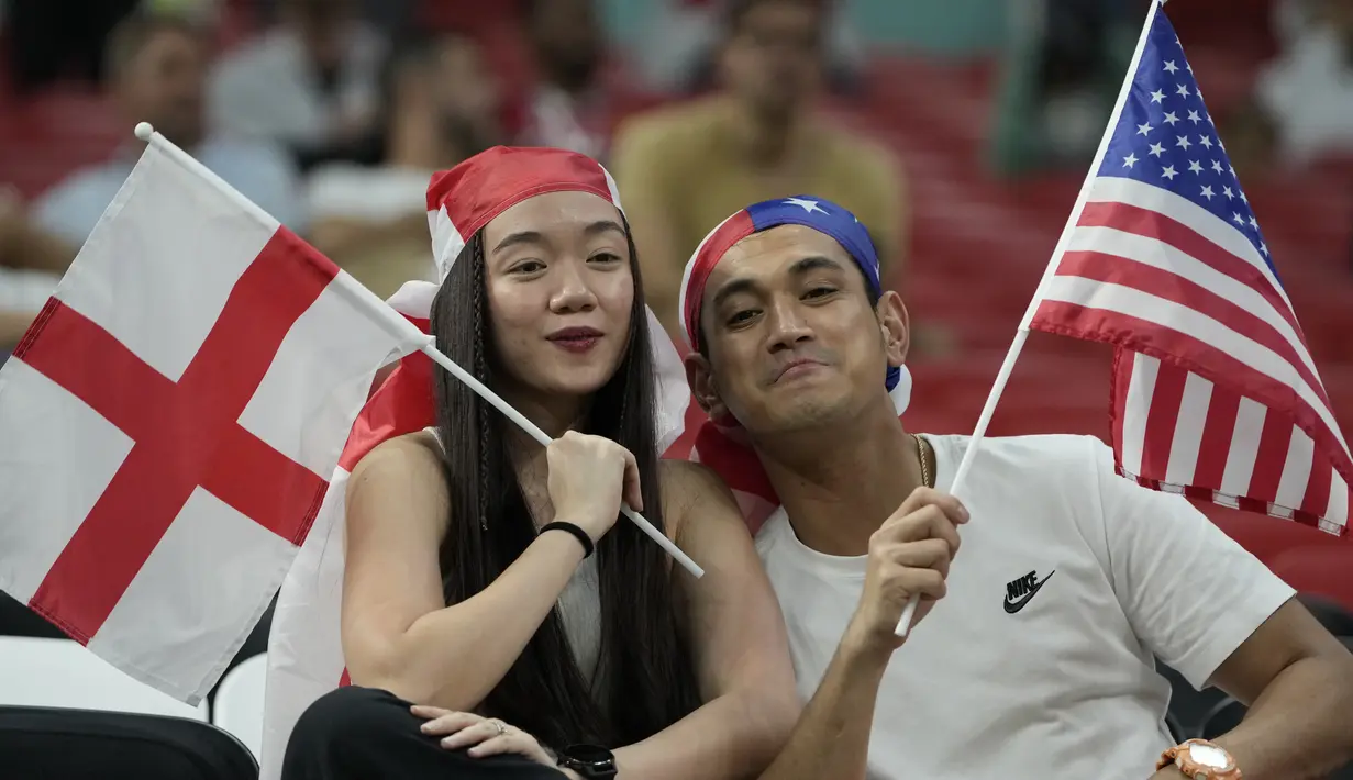 Fans wanita membawa bendera Inggris sebelum pertandingan grup B Piala Dunia 2022 Qatar antara Inggris dan Amerika Serikat di Stadion Al Bayt di Al Khor, Qatar, Sabtu (26/11/2022). Fans-fans cantik Inggris dan Amerika Serikat mengenakan atribut mendukung negaranya saat laga berlangsung. (AP Photo/Andre Penner)