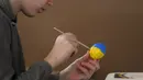 <p>Pengungsi anak-anak Ukraina melukis telur Paskah pada Kamis Putih di sebuah pusat pengungsi di Bucharest, Rumania, 21 April 2022. Orang Rumania yang mayoritas jemaat Ortodoks merayakan Minggu Paskah pada 24 April. (AP Photo/Andreea Alexandru)</p>