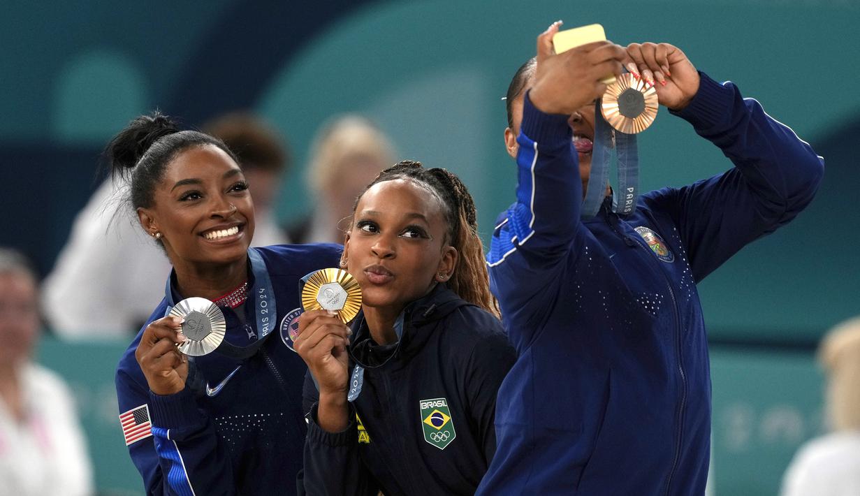 Pesenam Amerika Serikat  Jordan Chiles (kanan) melakukan swafoto bersama pesenam Brasil Rebeca Andrade (tengah), dan pesenam Amerika Serikat Simone Biles (kiri) pada cabang olahraga senam Olimpiade Paris 2024 di Bercy Arena, Paris, Prancis, Senin (05/08/2024). (AP Photo/Francisco Seco)