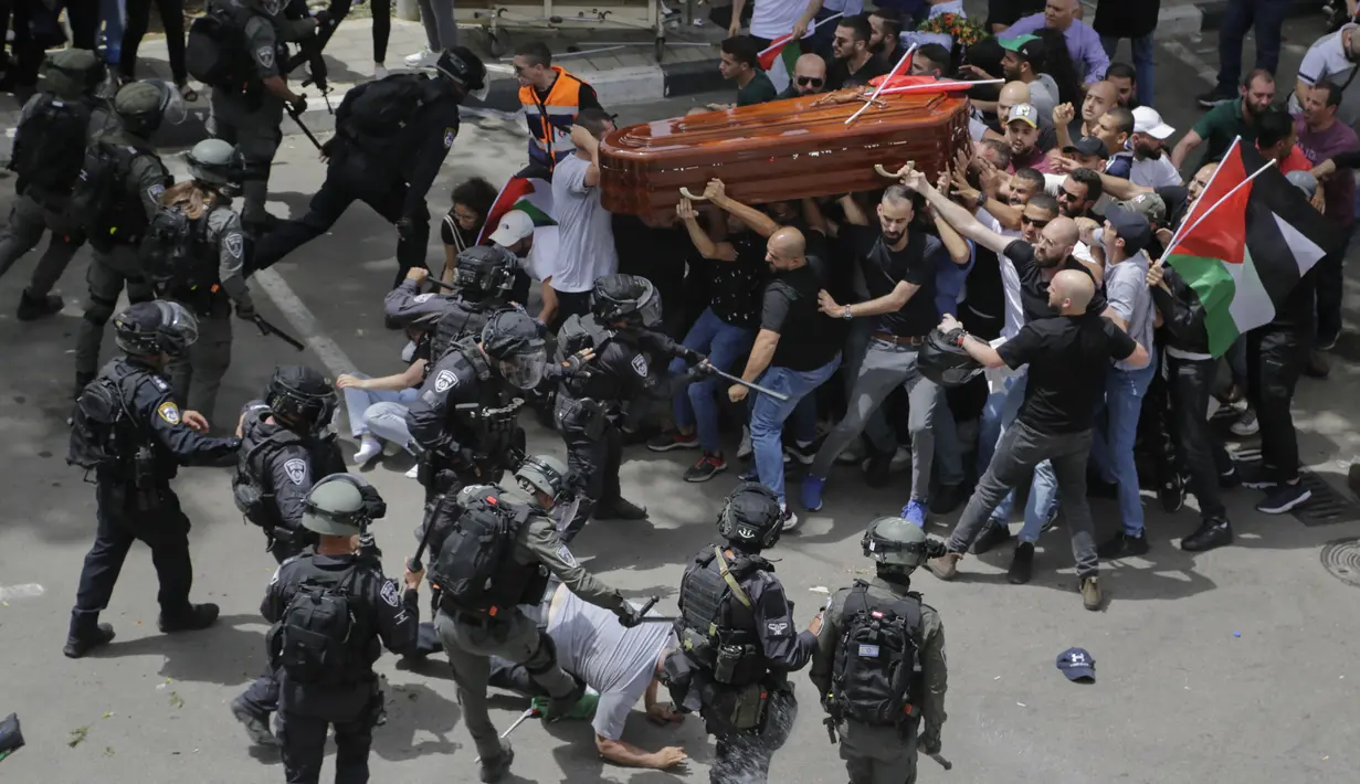 <p>Polisi Israel berhadapan dengan pelayat saat mereka membawa peti mati jurnalis veteran Al Jazeera yang terbunuh Shireen Abu Akleh selama pemakamannya di Yerusalem timur, 13 Mei 2022. Shireen Abu Akleh , seorang reporter Palestina-Amerika yang meliput konflik Timur Tengah selama lebih dari 25 tahun, terkena tembakan di kepala pada hari 11 Mei 2022 lalu dalam serangan militer Israel di kota Jenin di Tepi Barat. (AP Photo/Maya Levin)</p>