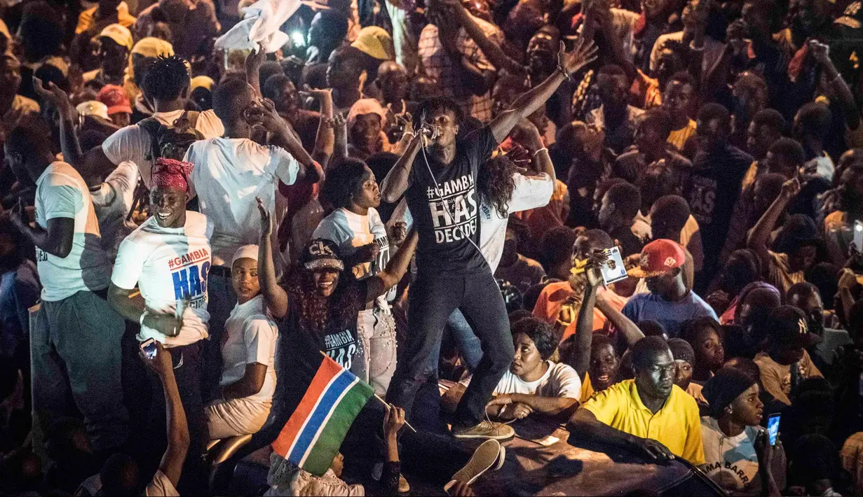 Ribuan rakyat menunggu iring-iringan kendaraan yang membawa Presiden baru Gambia, Adama Barrow, di Westfield, Gambia, Kamis (26/1). Adama Barrow, kembali ke negaranya, sepekan setelah ia dilantik di Kedutaan Gambia di Senegal. (AP Photo/Sylvain Cherkaoui)