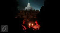 Wisatawan menyalakan lilin saat dilaksanakan program Earth Hour atau peringatan Hari Bumi oleh WWF (World Wildlife Fund for Nature), UNESCO dan Balai Konservasi Borobudur di Candi Borobudur, Magelang, Jawa Tengah, Sabtu (19/3) malam. (Foto: Boy Harjanto)