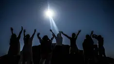 Para jemaah mengangkat tangan mereka ke arah matahari di piramida Teotihuacan di kota San Juan Teotihuacan, Negara Bagian Meksiko, saat perayaan equinoks musim semi pada 21 Maret 2024. (CARL DE SOUZA/AFP)