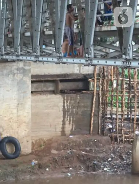 Anak-anak berdiri di jembatan saat berenang di Sungai Ciliwung, Rawajati, Jakarta, Selasa (17/12/2019). Meski debit air Sungai Ciliwung naik akibat hujan mengguyur Jakarta sejak siang hingga sore, anak-anak tersebut tetap nekat berenang tanpa memedulikan keselamatan. (Liputan6.com/Immanuel Antonius)