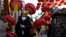 Seorang wanita berjalan melewati lentera tradisional Tiongkok di sepanjang gang menjelang Tahun Baru Imlek di Beijing, China, 2 Februari 2021. Imlek tahun ini jatuh pada tanggal 12 Februari 2021. (NOEL CELIS/AFP)