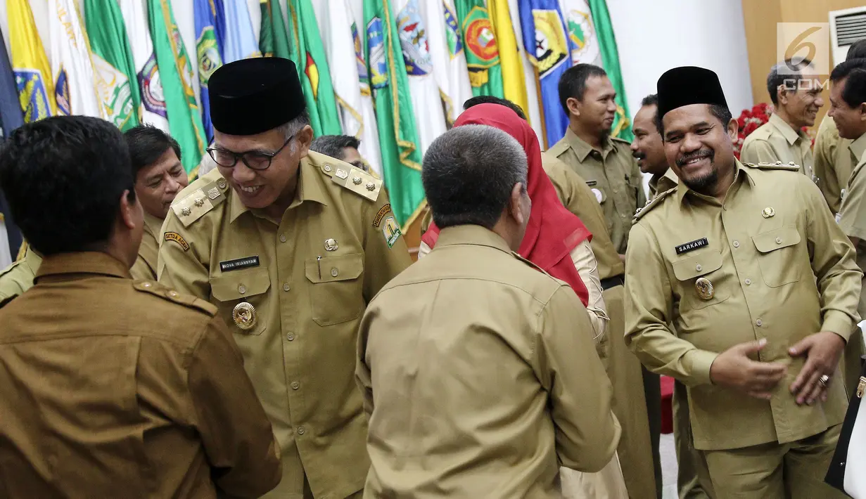 Plt Gubernur Aceh Nova Iriansyah dan Plt Bupati Bener Meriah, Tgk. H. Sarkawi menerima ucapan selamat usai serah terima surat penugasan Pelaksana Tugas (Plt) dari Mendagri di Kemendagri Jakarta, Senin (9/7). (Liputan6.com/Herman Zakharia)