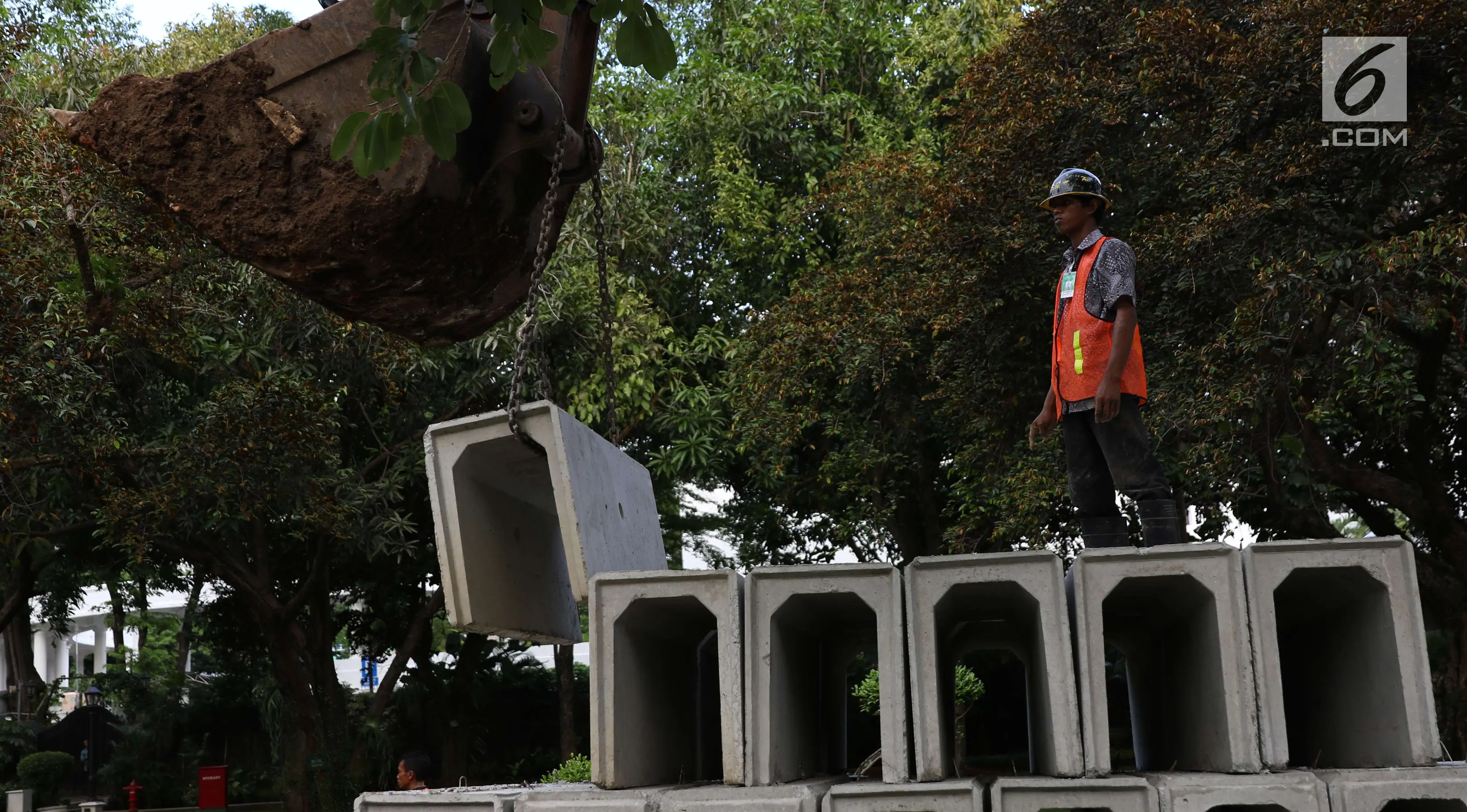 Pekerja mengamati alat berat melakukan perbaikan drainase Kompleks Istana Kepresidenan, Jakarta, Senin (18/12). Pengerjaan rehabilitasi drainase kawasan istana kepresidenan tersebut guna mengantisipasi ancaman banjir. (Liputan6.com/Angga Yuniar)
