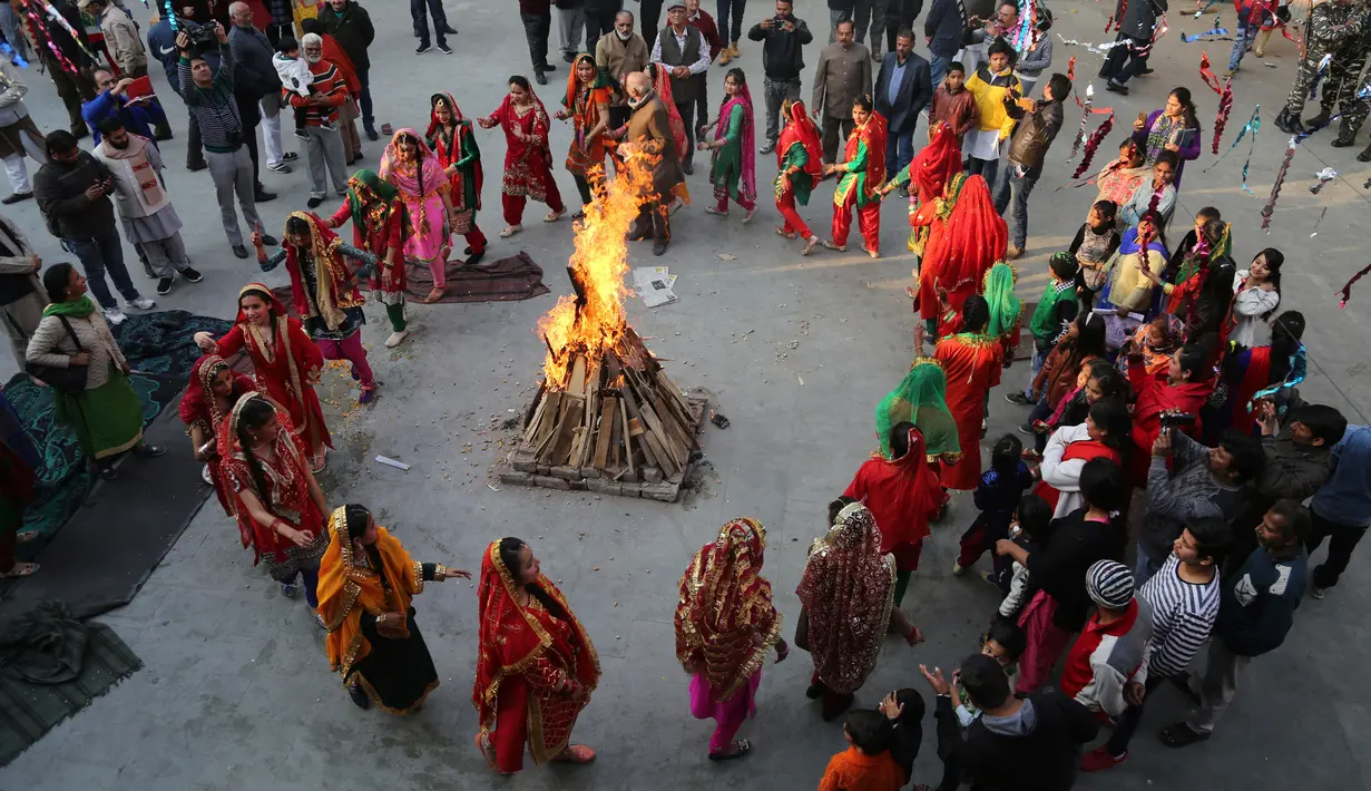 Gadis-gadis India berpakaian tradisional menari mengelilingi api unggun saat merayakan festival Lohri di Jammu, India (13/1). Festival Lohri ini banyak dirayakan oleh orang-orang dari wilayah Punjab di Asia Selatan. (AP Photo / Channi Anand)