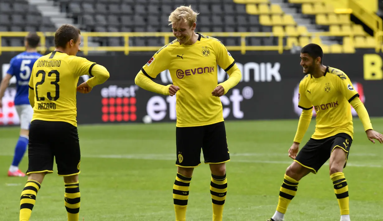 Pemain Borussia Dortmund merayakan gol yang dicetak oleh Thorgan Hazard ke gawang Schalke 04 pada laga Bundesliga di Stadion Signal Iduna Park, Sabtu (16/5/2020). Pandemi COVID-19 membuat pemain melakukan selebrasi jaga jarak. (AP/Martin Meissner)
