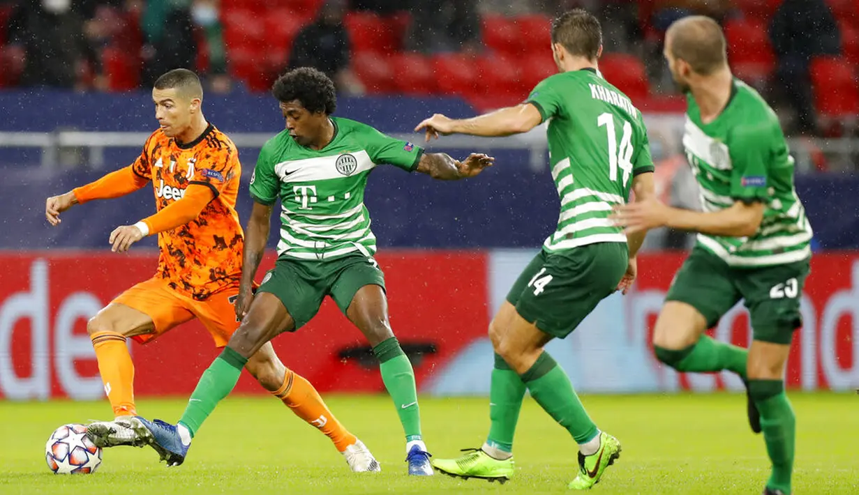 Pemain Juventus Cristiano Ronaldo (kiri) menggiring bola melewati pertahanan Ferencvaros pada pertandingan Grup G Liga Champions di Puskas Arena, Budapest, Hungaria, Rabu (4/11/2020). Juventus menang 4-1. (AP Photo/Laszlo Balogh)