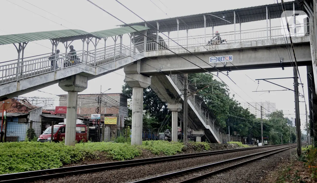 Pengendara sepeda motor melintasi jembatan penyeberangan orang (JPO) Stasiun Pasar Minggu Baru, Jakarta, Selasa (10/3/2020). JPO tersebut kerap disalahgunakan pengendara motor sebagai jalan alternatif untuk mempersingkat jarak tempuh meski rambu larangan sudah dipasang. (merdeka.com/Iqbal Nugroho)