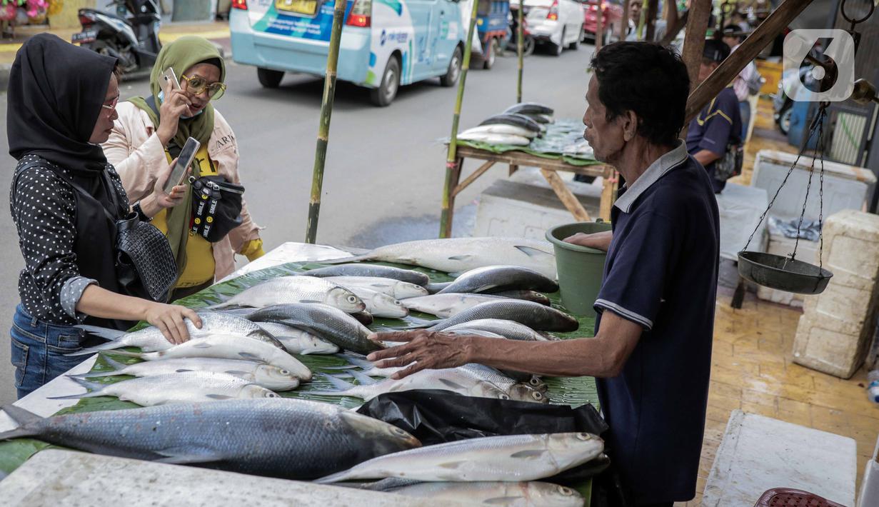 Pedagang ikan bandeng melayani pembeli di kawasan Rawa Belong, Jakarta, Selasa (21/1/2020). Bandeng yang biasanya menjadi hidangan khas saat Tahun Baru Imlek tersebut mulai ramai diperdagangkan di Rawa Belong. (Liputan.com/Faizal Fanani)