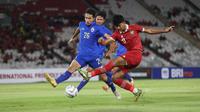 Striker Timnas Indonesia U-20, Arkhan Kaka (kanan) melepaskan tendangan yang berusaha diblok bek Thailand U-20, Puttaburin Jannawan pada laga uji coba di Stadion Utama Gelora Bung Karno (SUGBK), Senayan, Jakarta, Jumat (26/1/2024) malam WIB. (Bola.com/M Iqbal Ichsan)