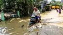 Warga nekat menerbos banjir dengan motornya di Perumahan PGP Jatiasih, Bekasi, Jawa Barat, Jumat (22/4). Ketinggian air mencapai 1,5 meter dari sebelumnya ketinggian mencapai hampir 4 meter. (Liputan6.com/Fery Pradolo)