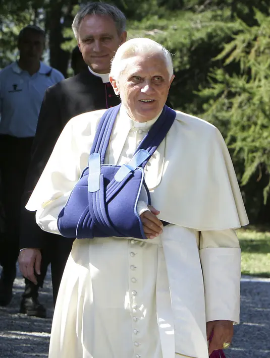 Paus Benediktus XVI, pergelangan tangan kanannya digips setelah jatuh larut malam di sebuah rumah liburan musim panas, Les Combes d'Introd, dekat Aosta, Italia utara, pada 29 Juli 2009.  Dilansir BBC, Sabtu (31/12/2022), ia memimpin Gereja Katolik selama kurang dari delapan tahun hingga, pada 2013, ia menjadi Paus pertama yang mengundurkan diri sejak Gregorius XII pada 1415. (AP Photo/Antonio Calanni, File)